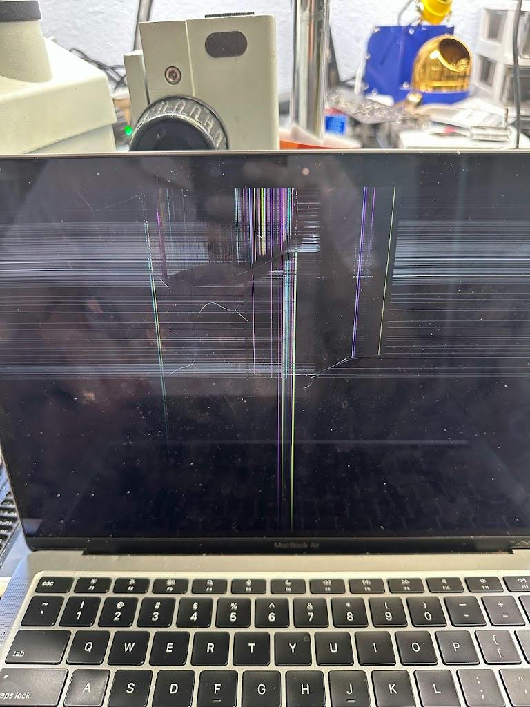 MacBook Air with a cracked, streaking screen on the iDoctor AZ repair bench in Tempe