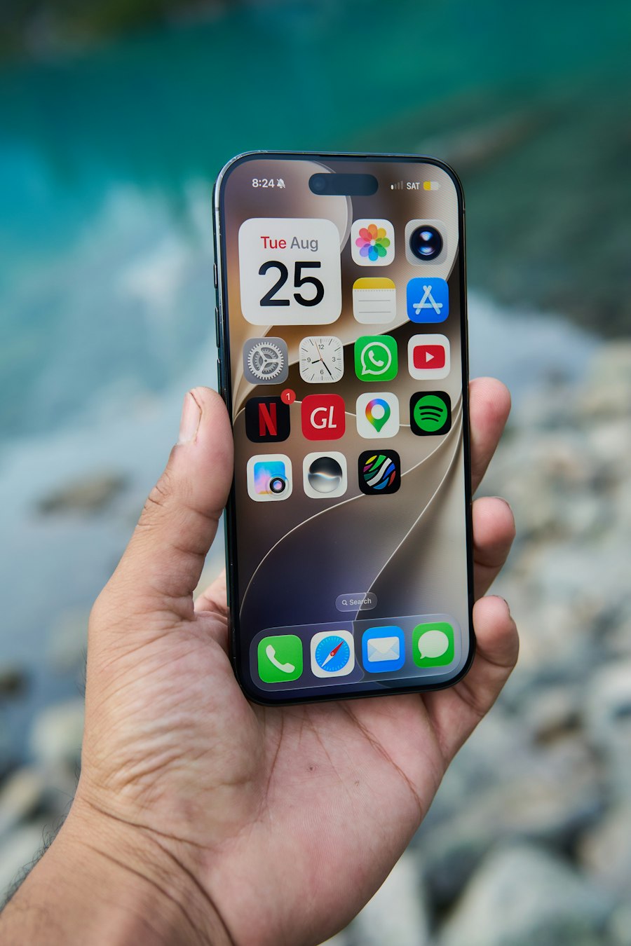 Hand holding an iPhone showing the Home Screen with apps and widgets